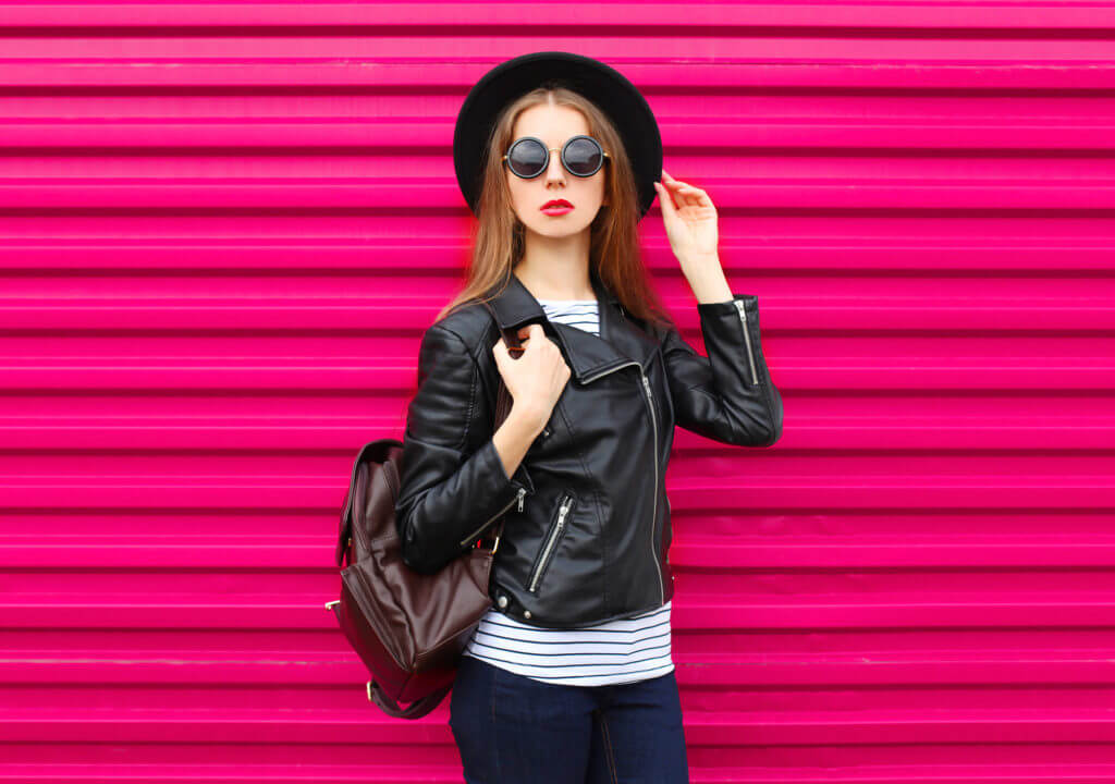 Fashion woman in black rock style over colorful pink background